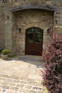 a stone building with a wooden door in front at Middle Flass Lodge in Bolton by Bowland
