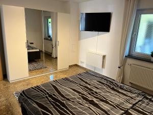 Un dormitorio con una cama y un televisor en la pared. en Ferienwohnung Mara, en Ettringen 5 fotos más