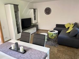 una sala de estar con un sofá y una mesa en Ferienwohnung Mara, en Ettringen