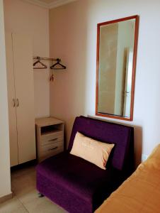 a bedroom with a purple chair and a mirror at Departamento 2 Complejo Sol de Oeste in San Juan
