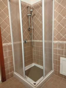 La salle de bains est pourvue d'une douche avec une porte en verre. dans l'établissement Holiday Villa, à Osilo