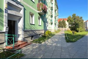 un edificio verde y blanco con una caja de flores en la puerta en Centrum Miasta en Stargard Szczeciński