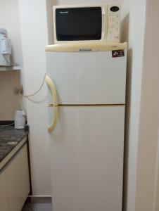 Departamento 2 Complejo Sol de Oeste في سان خوان: ميكروويف فوق ثلاجة في مطبخ