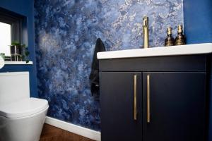 ein Badezimmer mit einem Waschbecken und einer blauen Wand in der Unterkunft The Longsands Home- Coastal Retreat with Hot Tub in Cullercoats