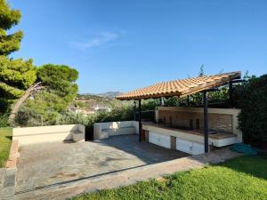 un giardino con panchina e gazebo di Summer Breeze Villa in Saronic Gulf ad Anávissos