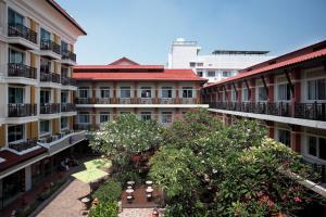 an apartment complex with a courtyard with trees and buildings at Rambuttri Village Plaza in Bangkok