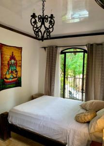 1 dormitorio con cama blanca y ventana en Casa Selva, en Cabuya