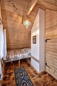 a small room with a bed in a log cabin at Prawie na końcu drogi in Skomielna Biała