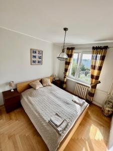 um quarto com uma cama grande e uma janela em Apartament Elizabeth em Gdynia