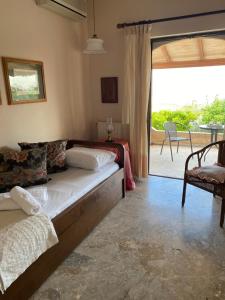 een woonkamer met een bed en een glazen schuifdeur bij Summer Breeze Villa in Saronic Gulf in Anavissos