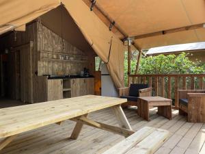 stół piknikowy w namiocie na pokładzie w obiekcie Lodges & Nature - 47 w Awinionie