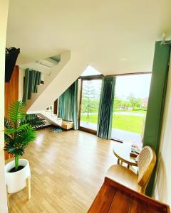 uma sala de estar com uma escada e uma mesa em BaanSuan Marigold บ้านสวนมาลีโกลด์ em Ban Madua Chumphon