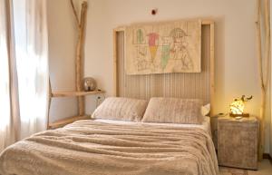 a bedroom with a bed with a painting on the wall at Thalassoxyla Portaria in Portariá