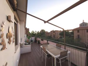 a balcony with a wooden table and chairs on it at Giglio Luxury Apartment - Chroma Italy in Rome