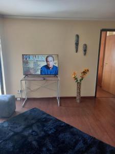 a room with a table with a picture of a man at Departamento Valdivia in Los Ángeles