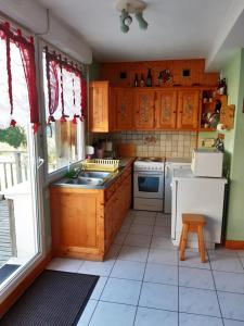 a kitchen with wooden cabinets and a sink at Les Angéliques in Gérardmer