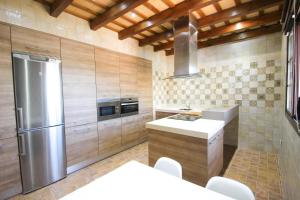 uma cozinha com um frigorífico de aço inoxidável e um lavatório em Vivienda Rural El Chirimbolo em Conil de la Frontera
