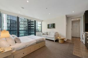 sypialnia z dużym łóżkiem i kanapą w obiekcie City Stays w Melbourne