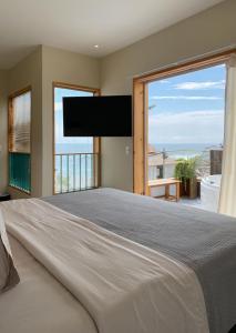 a bedroom with a large bed with a large window at Kauhuhu Casa Hotel in San Bartolo
