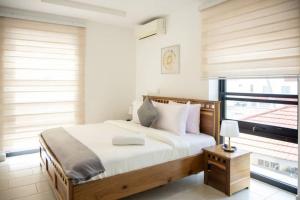 Schlafzimmer mit einem Bett und einem Fenster in der Unterkunft Labone Finest 2 Bed in Accra