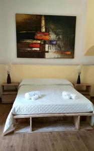 a bed in a bedroom with a painting on the wall at B&B I Viaggi Di Edo in Crotone