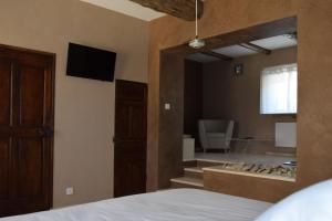 a bedroom with a bed and a bathroom with a tub at Résidence hôtelière et SPA des sources du gros noyer in Malaucène +38 photos