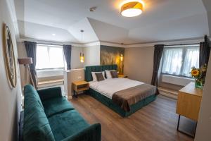 um quarto de hotel com uma cama e um sofá em B59 BOUTIQUE HOTEL em Câmpulung Moldovenesc