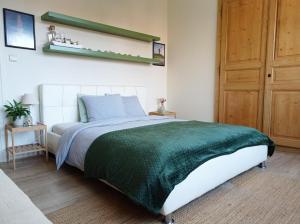 een slaapkamer met een bed met een groene deken bij B&B Emma in Brugge