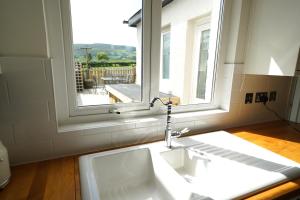 un bagno con lavandino e finestra di Gortnagory Cottage Carnlough a Carnlough