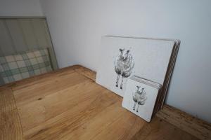 two photographs of two sheep on a wooden floor at Gortnagory Cottage Carnlough in Carnlough