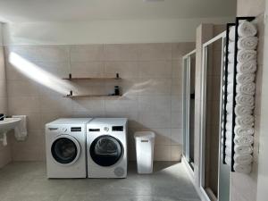 a bathroom with a washing machine and a sink at Penzion NoFasada in Bzenec