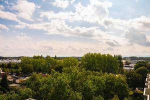 uma cidade sob um céu nublado com árvores e edifícios em Modern, fully equipped apartment, ideal for Messe fair em Hanôver
