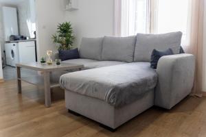 a living room with a couch and a table at Appartement Hyper Centre Cosy avec Balcon in Châteaudun