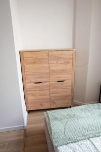 a wooden dresser in a bedroom with a bed at VS Apartments - apartament nr 33 in Łódź