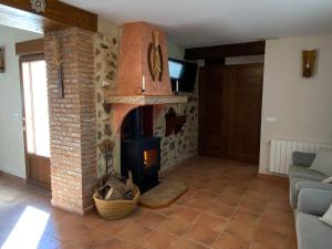 San Agustín的住宿－Casa Rural El Aljibe，客厅设有砖砌壁炉和沙发。