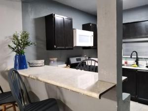 a kitchen with a white counter top and black cabinets at Apto Super Privado#1 Planta baja in Mexicali