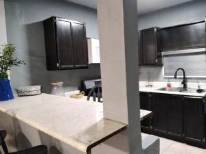 a kitchen with black cabinets and a white counter top at Apto Super Privado#1 Planta baja in Mexicali