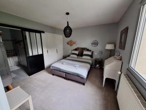 - une chambre avec un lit, un bureau et une fenêtre dans l'établissement Woodland's House, à Hermanville-sur-Mer