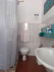 a bathroom with a toilet and a sink and a tub at Old house in Tarrafal +18 photos