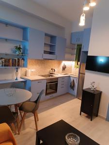 a kitchen with blue cabinets and a table and chairs at Sigma Acropolis GF in Athens