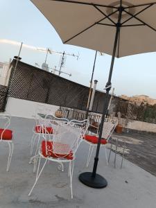 a table and chairs with an umbrella on a patio at Sigma Acropolis GF in Athens