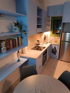 a kitchen with blue cabinets and a table with chairs at Sigma Acropolis GF in Athens