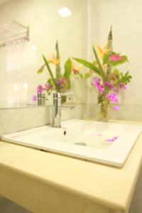 lavabo con flores en el espejo en Garden Resort, en Vang Vieng