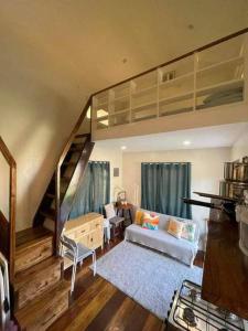 a living room with a loft bed and a couch at Luxury Tiny Home with Free* Use of Tiny Car in El Nido