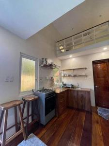a kitchen with a stove and two stools in it at Luxury Tiny Home with Free* Use of Tiny Car in El Nido