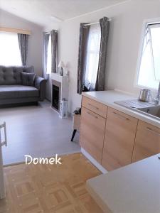 a kitchen and living room with a couch and a sink at Azur Domki blisko plaży in Mielno