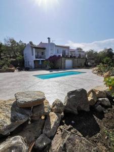 - une piscine avec des rochers en face d'une maison dans l'établissement Dépendance dans Mas traditionnel avec piscine, à Argelès-sur-Mer