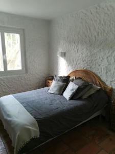 - une chambre avec un lit doté d'oreillers et d'une fenêtre dans l'établissement Dépendance dans Mas traditionnel avec piscine, à Argelès-sur-Mer
