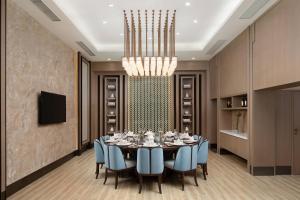 uma sala de jantar com uma mesa e cadeiras e um lustre em Courtyard by Marriott Hangzhou West em Hangzhou