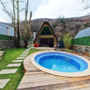 a small swimming pool in a yard with a house at Sapanca Sudere Bungalov 2 in Sakarya
